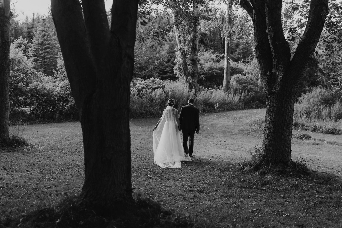 Bride and groom walking together through a field on their wedding day