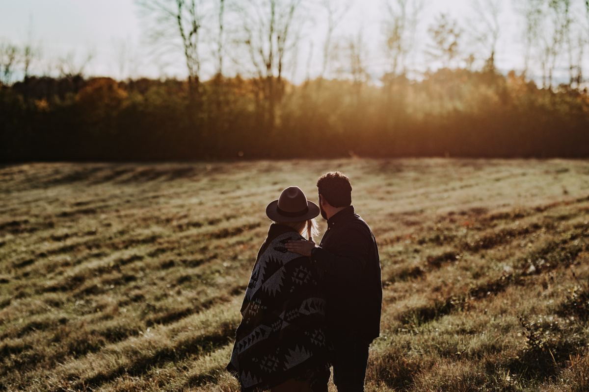Couple standing in field on a cool autumn day