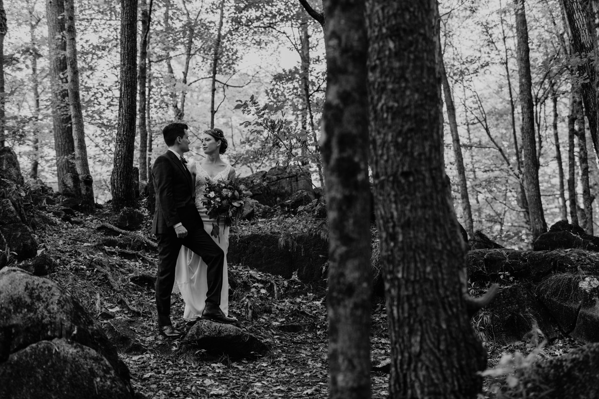 Black and white portrait of couple standing in the forest in Gatineau Park