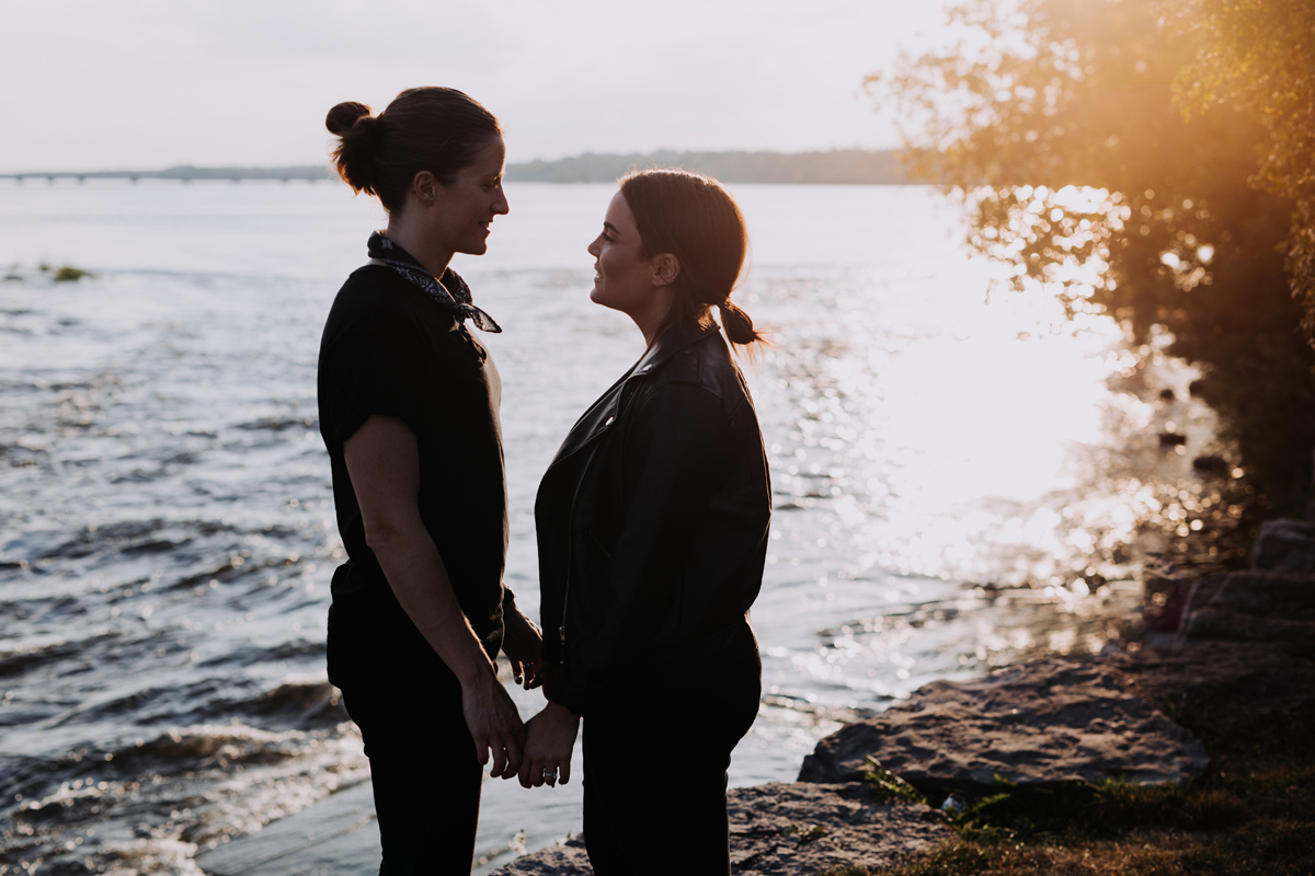 Couple standing in front of Ottawa river at sunset